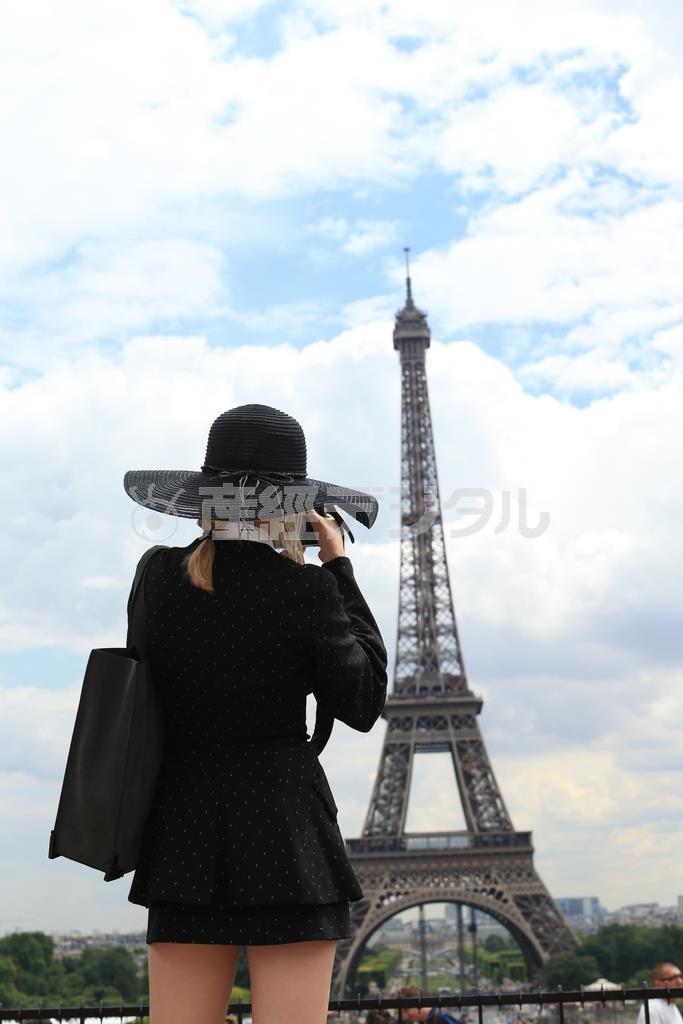 一人旅のバカンスらしいツバの大きな帽子をかぶった女性が写真を撮っている後ろ姿を撮りました。エッフェル塔と被写体がかぶりすぎず、離れすぎずの距離を探して撮りました＝２０１４年６月３０日、フランス・首都パリ（須藤夕子さん撮影）