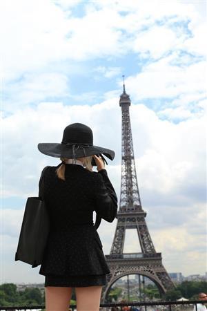 一人旅のバカンスらしいツバの大きな帽子をかぶった女性が写真を撮っている後ろ姿を撮りました。エッフェル塔と被写体がかぶりすぎず、離れすぎずの距離を探して撮りました＝２０１４年６月３０日、フランス・首都パリ（須藤夕子さん撮影）