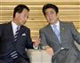 臨時閣議に臨み、甘利明経済再生担当相（左）と話し込む安倍晋三首相＝１４日午前、首相官邸