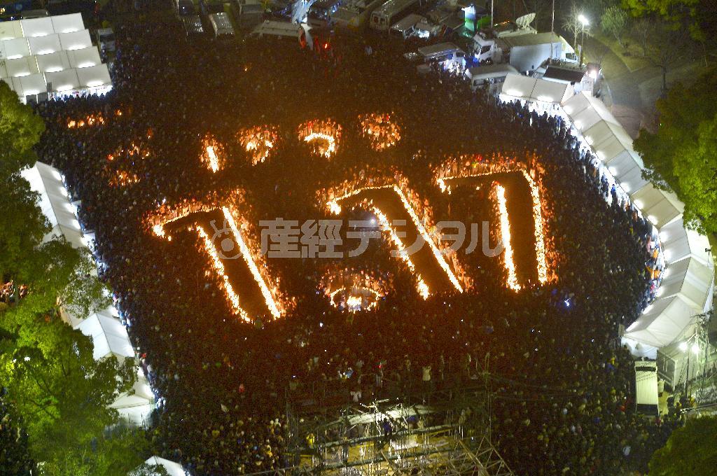 神戸市中央区の東遊園地で行われた「阪神淡路大震災１・１７のつどい」。会場を埋め尽くした人々が地震発生時刻の午前５時４６分に黙祷（もくとう）を捧げた＝２０１５年、兵庫県（土井繁孝撮影）