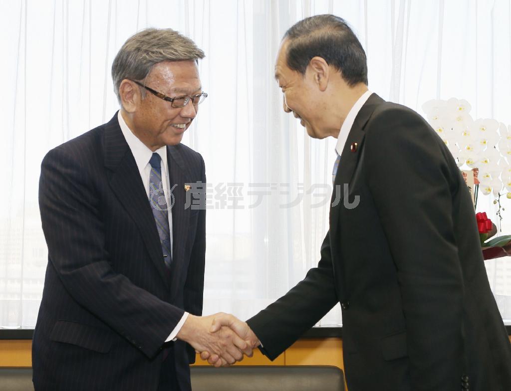 山口俊一（しゅんいち）沖縄北方担当相（右）と握手する翁長雄志（おなが・たけし）沖縄県知事＝２０１４年１２月２６日、東京都千代田区永田町（共同）