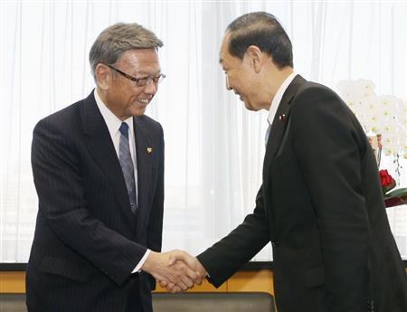 山口俊一（しゅんいち）沖縄北方担当相（右）と握手する翁長雄志（おなが・たけし）沖縄県知事＝２０１４年１２月２６日、東京都千代田区永田町（共同）