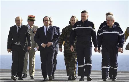 １月１４日、原子力空母シャルル・ドゴールの艦上を歩くフランスのフランソワ・オランド大統領（左から３人目）。マニュエル・バルス首相の「テロとの戦争」宣言を受け、艦上演説で仏軍削減計画の見直しを表明した＝２０１５年（ロイター）