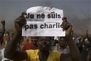 １月１７日、フランス週刊紙をめぐりニジェールの首都ニアメーで抗議デモを行う男性。「私はシャルリではない」と書かれたメッセージを掲げている＝２０１５年（ロイター）