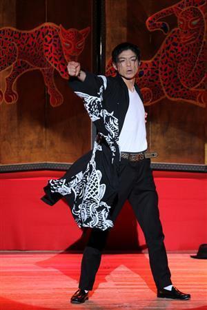 琳派（りんぱ）４００年イベントのオープニングで華麗なダンスを披露するマイケルダンスパフォーマーのＭＡＳＡＫＩさん。壁画絵師の木村英輝さんの描いたジャガーの屏風絵をバックに、木村さんのコイの絵をモチーフにしたジャケットで登場した＝２０１５年１月１２日、京都市上京区の京都府立文化芸術会館（田中幸美撮影）