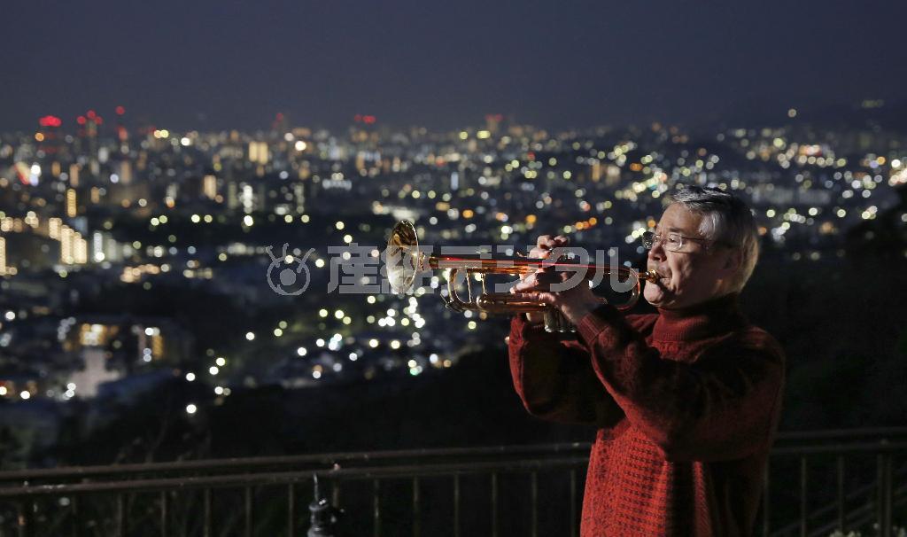 神戸市中央区で、犠牲者の冥福を祈りトランペットを吹く松平晃さん＝２０１５年１月１７日早朝、兵庫県（共同）