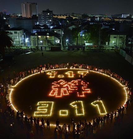 神戸市長田区の市立真野小でともされた東日本大震災の被災地との「絆」を記すろうそくの明かり＝２０１５年１月１７日午前５時４６分、兵庫県（共同）