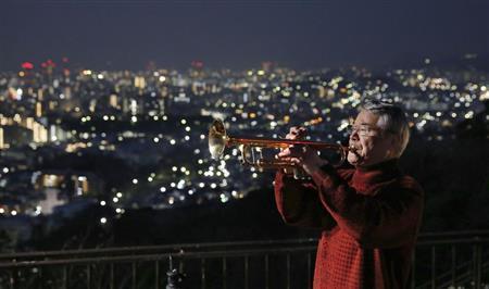 神戸市中央区で、犠牲者の冥福を祈りトランペットを吹く松平晃さん＝２０１５年１月１７日早朝、兵庫県（共同）
