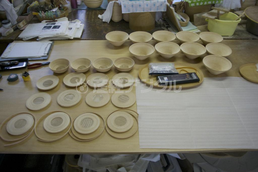 芯材にテープ状のブナを巻き付けた商品の原型（左手前）。この状態から湯呑を使ってインテリアや器が仕上げられていく＝２０１４年８月２９日（提供写真）