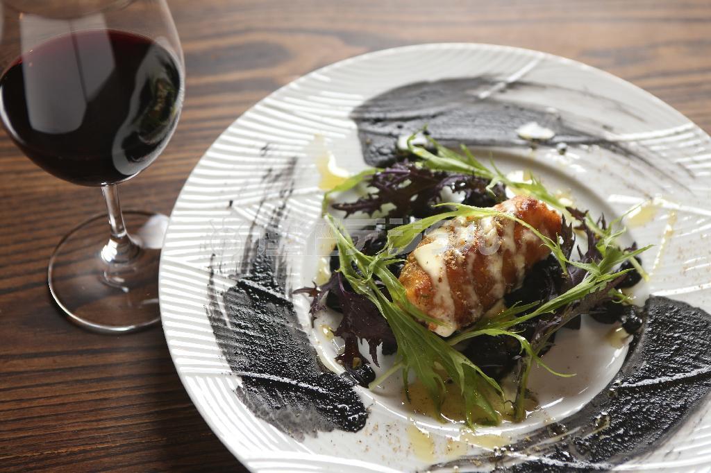 お皿の外周に書道のごとく描かれた紋甲イカのイカスミソースが印象的な「タラの白子のムニエル＿イカスミソース」（１２００円）＝２０１４年１２月１９日、京都市中京区（志儀駒貴撮影）