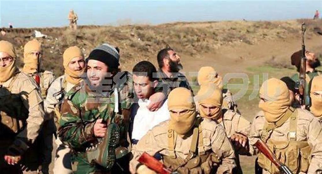 ２０１４年１２月２４日、シリア北部ラッカで、イスラム国の兵士らに連行されるヨルダン軍パイロット（中央）。イスラム国系ウェブサイトが公開した。ヨルダンはかねてから、このパイロットとサジダ・リシャウィ死刑囚との交換を模索していたとされる（ＡＰ）