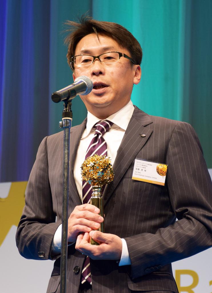 壇上で喜びを語るキリンの佐藤潤・グローバル人事室長