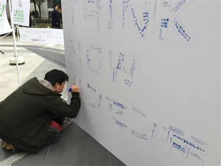 １月２５日の「世界ハンセン病の日」に都内で行われた街頭キャンペーンで、ボードに応援メッセージを書き込む若者＝２０１５年（日本財団撮影）