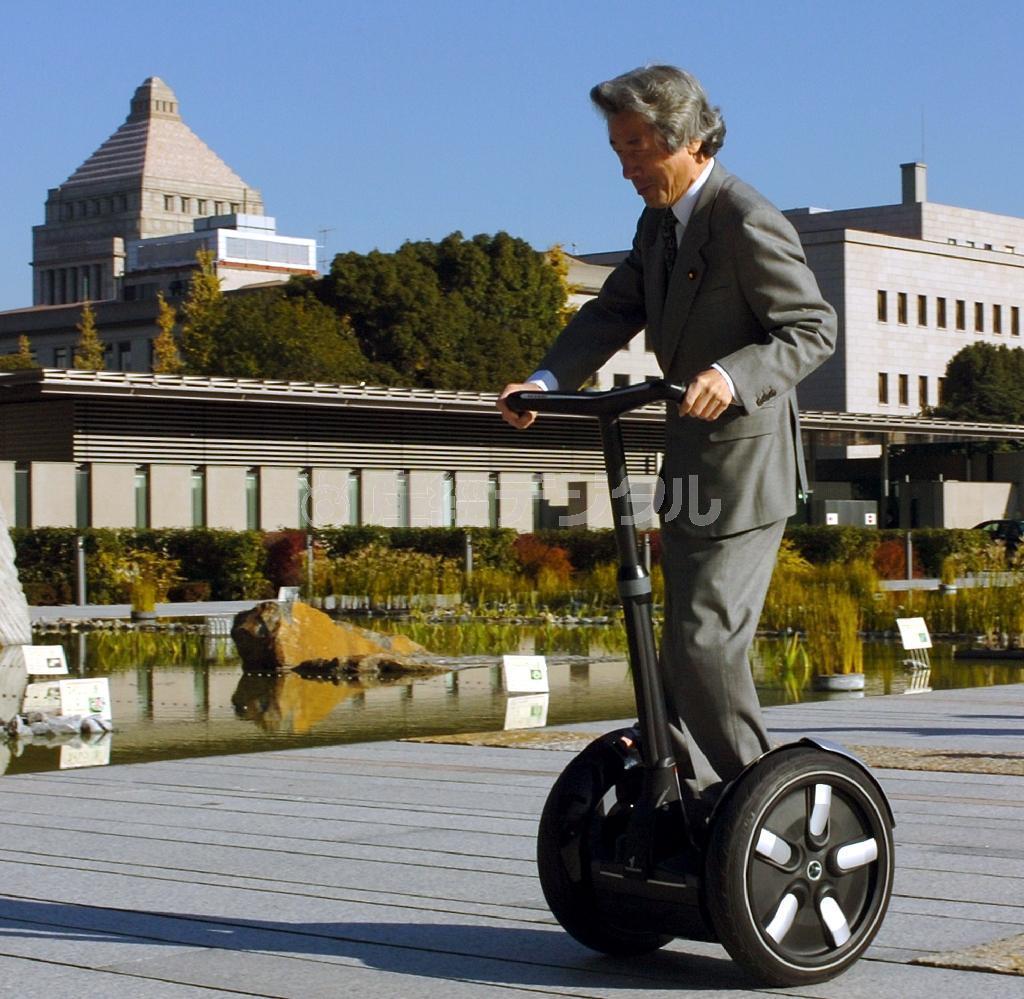 ブッシュ米大統領から贈られた電動２輪車「セグウェイ」で首相官邸に向かう小泉純一郎首相＝平成１７（2005）年１２月１６日（代表撮影撮影）