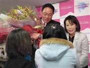 山梨県知事選で初当選を確実にし、支持者から花束を受け取る後藤斎（ひとし）氏（左）＝２０１５年１月２５日、山梨県甲府市（牧井正昭撮影）