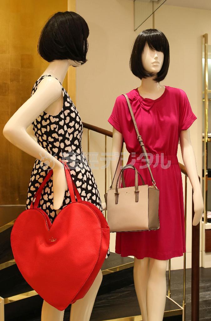 ２月の新作はバレンタインデーを意識。黒地に白のハートモチーフ（左、５万３０００円）のワンピースには鮮やかなピンク色のハート型トートバッグ（５万３０００円）をあわせて小粋に。ピンクのコットンジャージーにリボンをあしらったワンピース（右、２万７０００円）にはベージュのバイカラーのバッグ（４万５０００円）で「大人」を演出＝２０１５年１月２８日、東京都中央区（宮崎裕士撮影）