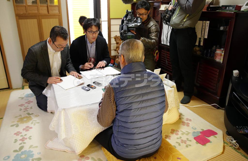 湯川遥菜（はるな）さんが殺害されたとする画像がインターネット上に流れたことを受け、自宅で代表取材に応じる湯川さんの父親（後ろ姿）。政府や関係者に謝罪した上で深い謝意を示した父親の態度に、韓国世論は感嘆した＝２０１５年１月２５日、千葉県千葉市花見川区（代表撮影）