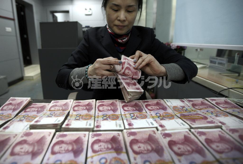 人民元の紙幣を数える中国の銀行員。人民元を国際通貨として認定するかどうかの検討が行われている＝２０１５年１月２８日、中国・安徽省淮北市（ＡＰ）