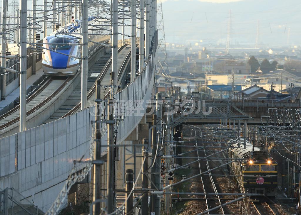 デビューを控えた北陸新幹線と引退間近の寝台特急「トワイライトエクスプレス」（右下）との一瞬の出合い。今春のダイヤ改正以降は見ることのできない、今だけの光景だ＝２０１５年２月６日、富山県富山市（恵守乾撮影）