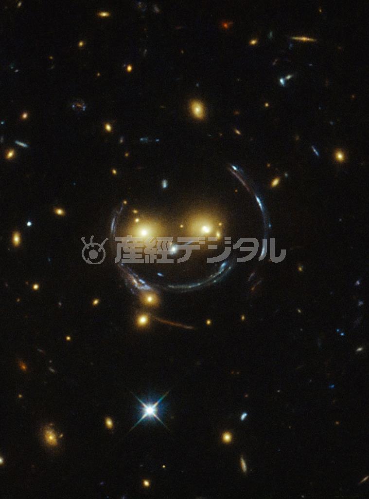 ハッブル宇宙望遠鏡で撮影された宇宙空間に浮かぶ笑顔のように見える銀河団＝２０１５年（ＮＡＳＡ提供、ロイター）