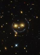 ハッブル宇宙望遠鏡で撮影された宇宙空間に浮かぶ笑顔のように見える銀河団＝２０１５年（ＮＡＳＡ提供、ロイター）