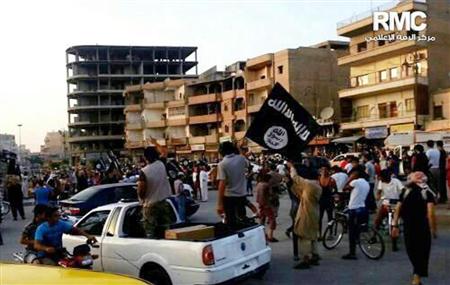 シリア北部ラッカを行進する過激派「イスラム国」の戦闘員ら。２０１４年６月３０日に反体制派メディアが公表した（ＡＰ＝共同）