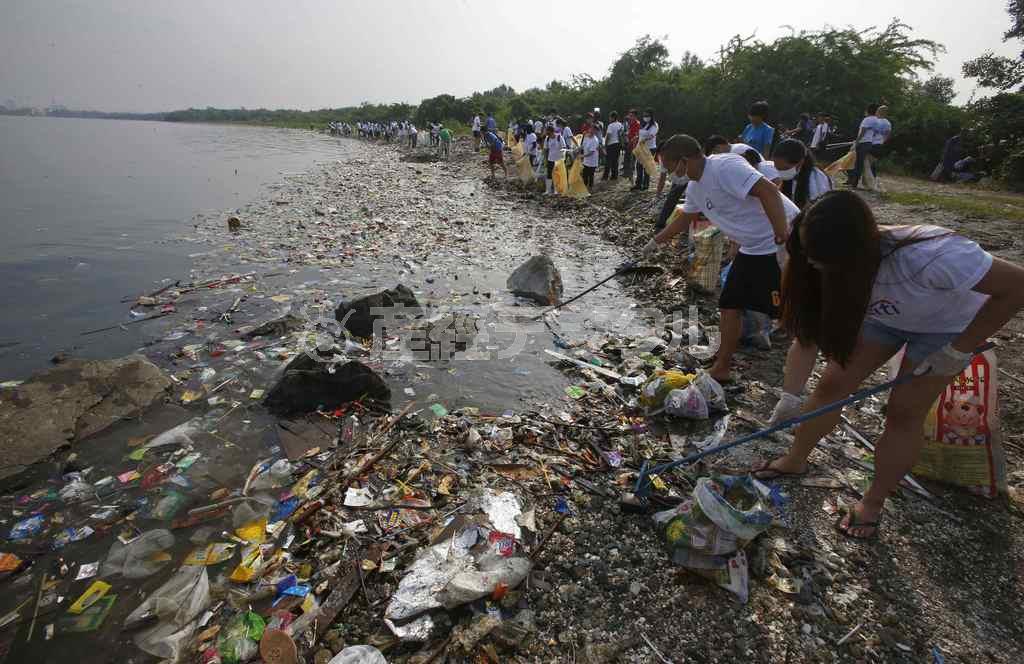 プラスチックごみを含む大量のごみが海流に乗って押し寄せたフィリピン・マニラ湾の海岸で、清掃作業を行うボランティアたち。プラスチックごみの管理方法整備は、世界的な喫緊の課題だ＝２０１５年２月１３日（ロイター）