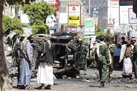 イエメン中部イッブで破壊された車の周りに集まる武装組織「フーシ派」の民兵＝２０１５年８月１４日（ロイター）