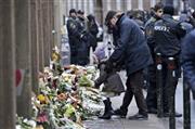 襲撃されたシナゴーグ（ユダヤ教会堂）前に花束を供える少女＝２０１５年２月１５日、デンマーク・首都コペンハーゲン（ＡＰ）