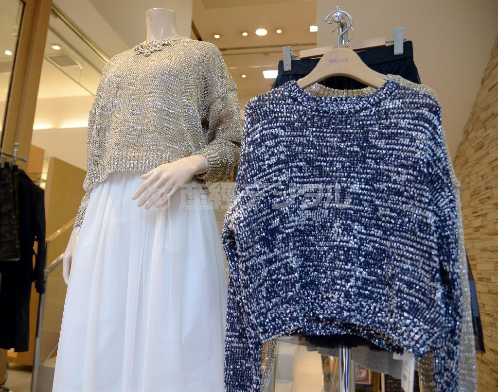 シルバーラメの入ったコットン素材のニット（１万８０００円）はゴールド（左）と紺（右）の２種類。定番の白のクチュールスカート（１万４０００円）を合わせて＝２０１５年２月６日、東京都中央区（鴨川一也撮影）