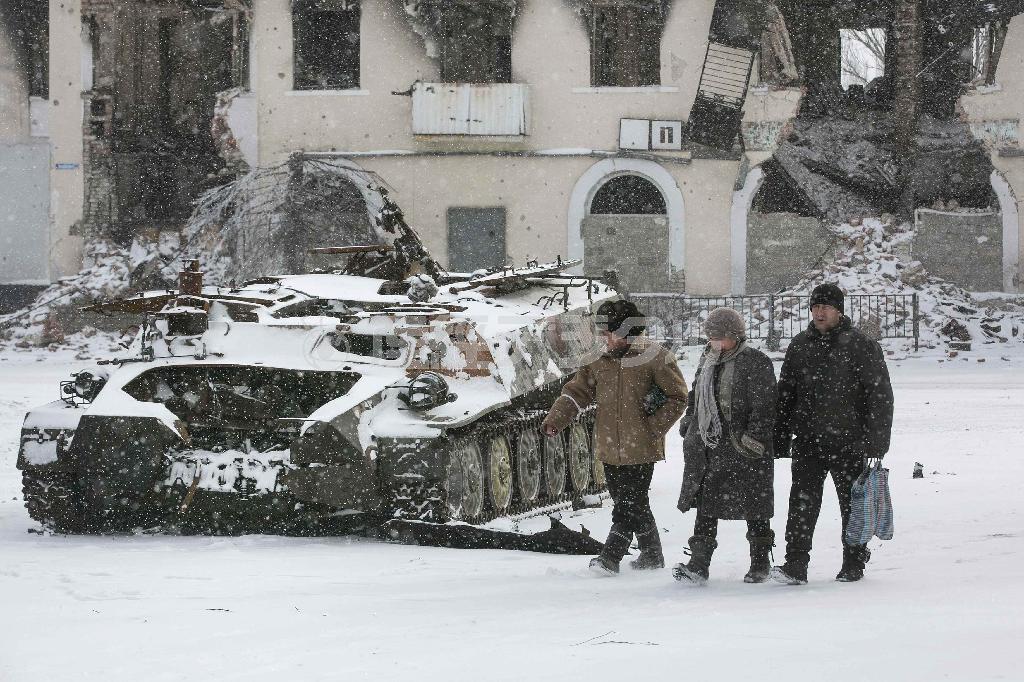 ２月１６日、ウクライナ東部デバリツェボ西方の町で、破壊されたウクライナ軍の軍用車の脇を歩く住民＝２０１５年（ロイター）