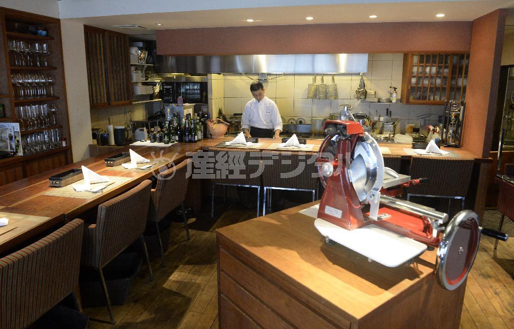 木がふんだんに使われた落ち着いた店内。中央には生ハムのスライサーが置かれ、食べたい分だけセルフでスライスできる＝２０１５年２月２日、京都市中京区（甘利慈撮影）