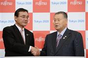 ２０２０年東京五輪・パラリンピック組織委員会と「ゴールドパートナー」の契約を結び、握手する富士通の山本正已社長（左）と組織委の森喜朗会長＝１９日午後、東京都港区