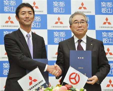 果樹農家支援の協定を結び、記者会見で握手する福島県郡山市の品川万里市長（右）と三菱商事復興支援財団の野島嘉之代表理事＝２０日午後、東京都千代田区