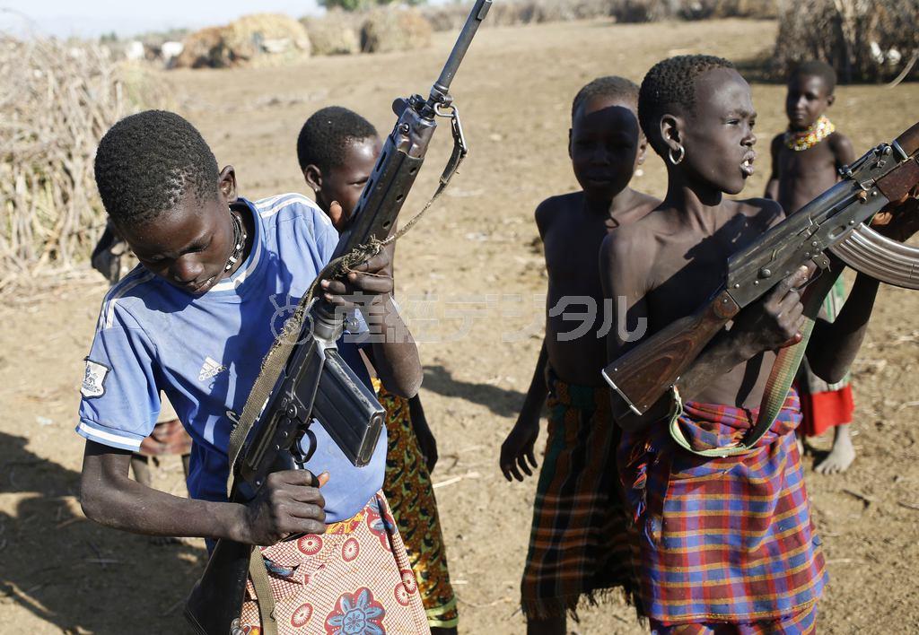 南スーダンとの国境地帯で、銃を手にするケニアのトゥルカナ族の少年たち。両国の国境紛争にも、それぞれの少年兵が駆り出されている＝２０１４年１２月２１日、イレミ・トライアングル（ロイター）