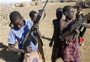 南スーダンとの国境地帯で、銃を手にするケニアのトゥルカナ族の少年たち。両国の国境紛争にも、それぞれの少年兵が駆り出されている＝２０１４年１２月２１日、イレミ・トライアングル（ロイター）