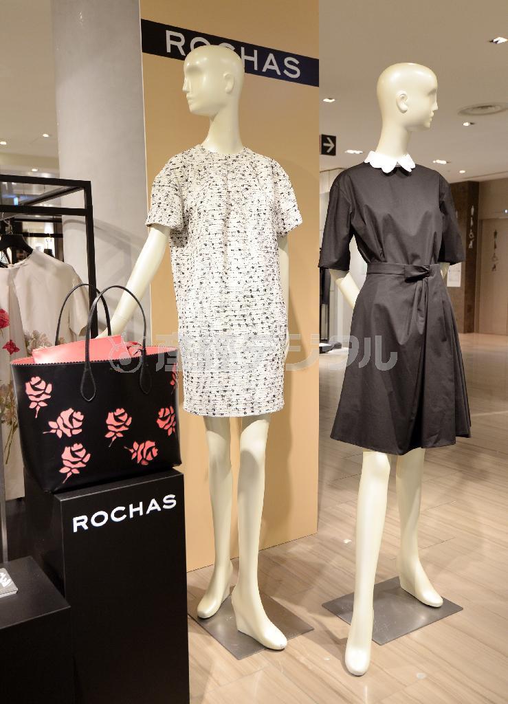 白い丸襟がアクセントの紺のワンピース（右、７万８０００円）と白地に黒の模様をあしらったすっきりしたワンピース（左、２０万５０００円）。手前のバッグは春夏のテーマであるバラをあしらっている（２４万円）＝２０１５年２月９日、東京都中央区銀座（宮川浩和撮影）