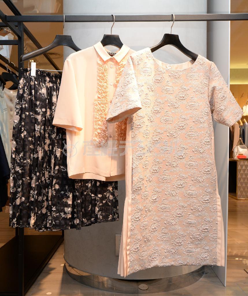 ジャガード織に白いバラを描いた華やかなワンピース（右、２１万５０００円）、華やかなひだをあしらったトップス（中、１２万８０００円）は、黒地にピンクの花模様のスカート（左、２４万５０００円）とあわせてすっきり着こなす＝２０１５年２月９日、東京都中央区銀座（宮川浩和撮影）