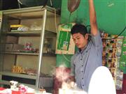 大きな茶こしを振りかざして、約１メートルの高さからコーヒーを落下させる伝統的なコーヒーのいれ方。店によってはコーヒー職人の技を楽しみながらコーヒーを飲むこともできる＝インドネシア・アチェ州バンダアチェ、コーヒー屋台「ブルリアン」（横山裕一撮影）