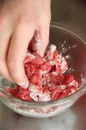 ブロッコリーと牛肉のエスニック炒め（作り方１）＿＿牛肉に塩、こしょう、酒をなじませ、かたくり粉をもみこむ（田中幸美撮影）