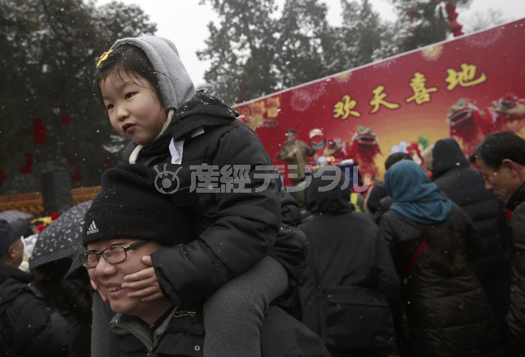 春節の休暇中に北京のイベント会場で父親に肩車をしてもらう幼児。北京の子供たちが受け取るお年玉は年々高額化し、今では平均で９万円を超えるとされる＝２０１５年２月２０日、中国・首都北京市（ＡＰ）