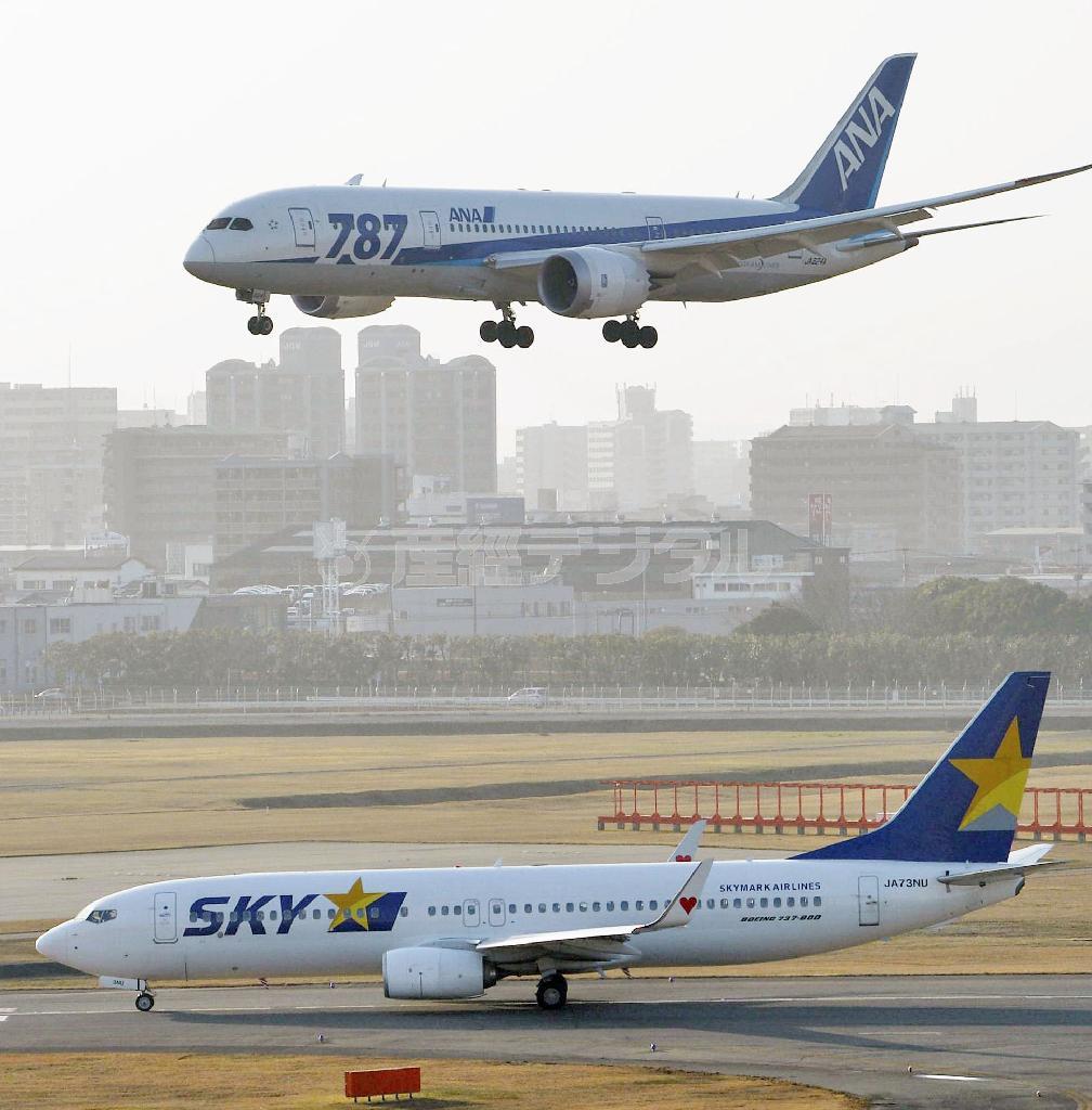 着陸する全日空機と離陸を待つスカイマーク機＝２０１５年２月２３日午後、福岡県福岡市博多区・福岡空港（共同）