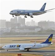 着陸する全日空機と離陸を待つスカイマーク機＝２０１５年２月２３日午後、福岡県福岡市博多区・福岡空港（共同）