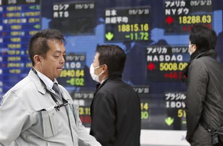 ３日、都内の証券会社店頭で小幅反落した日経平均株価を示す株価ボード前を歩く人（ＡＰ）