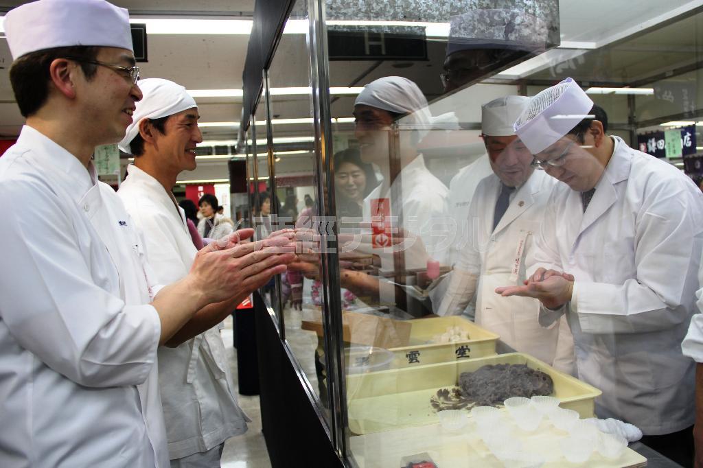 今回和菓子職人デビューを果たした「彩雲堂」の山口周平さん（右端）。仲間のサポートと声援を受け、ごんち餅を作り上げると拍手がわき起こった＝２０１５年２月２５日、神奈川県横浜市西区の横浜高島屋（田中幸美撮影）