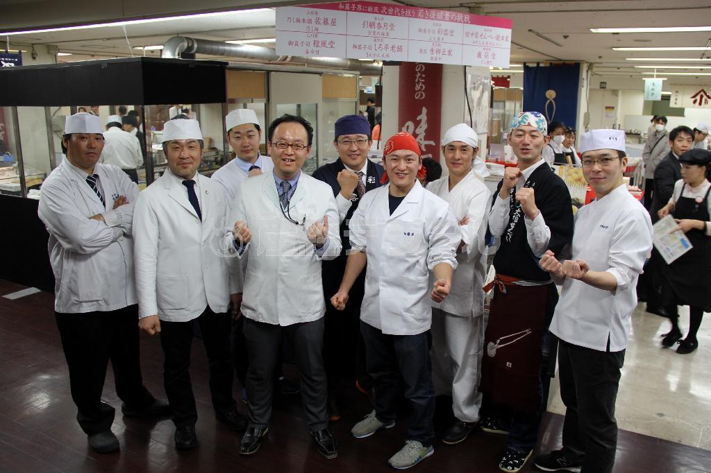 イベント初日、開店前に集結して気勢を上げるワカタクのメンバー。左から須永友和さん、岩佐昇さん、安田卓司さん、高島屋和菓子バイヤーの畑主税（ちから）さん、山口周平さん、佐藤慎太郎さん、内田弘守さん、田中裕介さん、引網康博さん＝２０１５年２月２５日、神奈川県横浜市西区の横浜高島屋（田中幸美撮影）