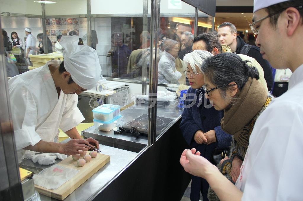 桜にちなんだ生菓子の実演に見入る客に、ワカタクのメンバーが実況説明するなど随所で連携プレーが見られた＝２０１５年２月２５日、神奈川県横浜市西区の横浜高島屋（田中幸美撮影）