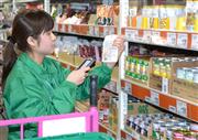 セブン＆アイの「ネットスーパー西日暮里店」で、専用機器を使いながら注文の商品を選ぶスタッフ＝５日、東京都荒川区（山口暢彦撮影）