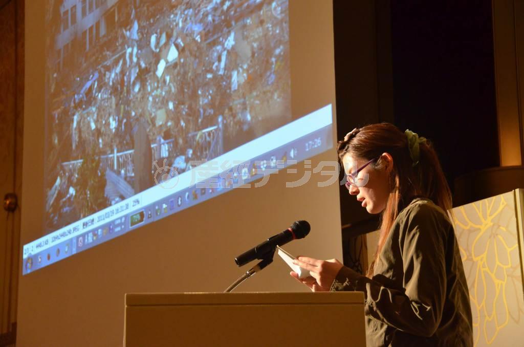 震災直後の宮城県石巻市内の写真をスクリーンに映し、当時の体験を語る榊美紗子さん＝２０１５年３月３日、福岡県福岡市博多区（安藤歩美撮影）