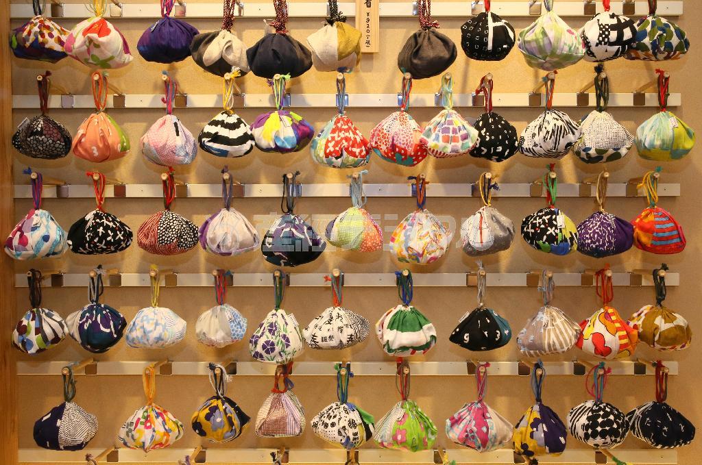 １階の「ＳＯＵ・ＳＯＵ＿布袋」の壁一面にびっしり並ぶ「おむすび巾着」（９２０円）。女子なら眺めているだけで楽しいはずだ＝２０１５年２月１３日、京都市中京区（志儀駒貴撮影）